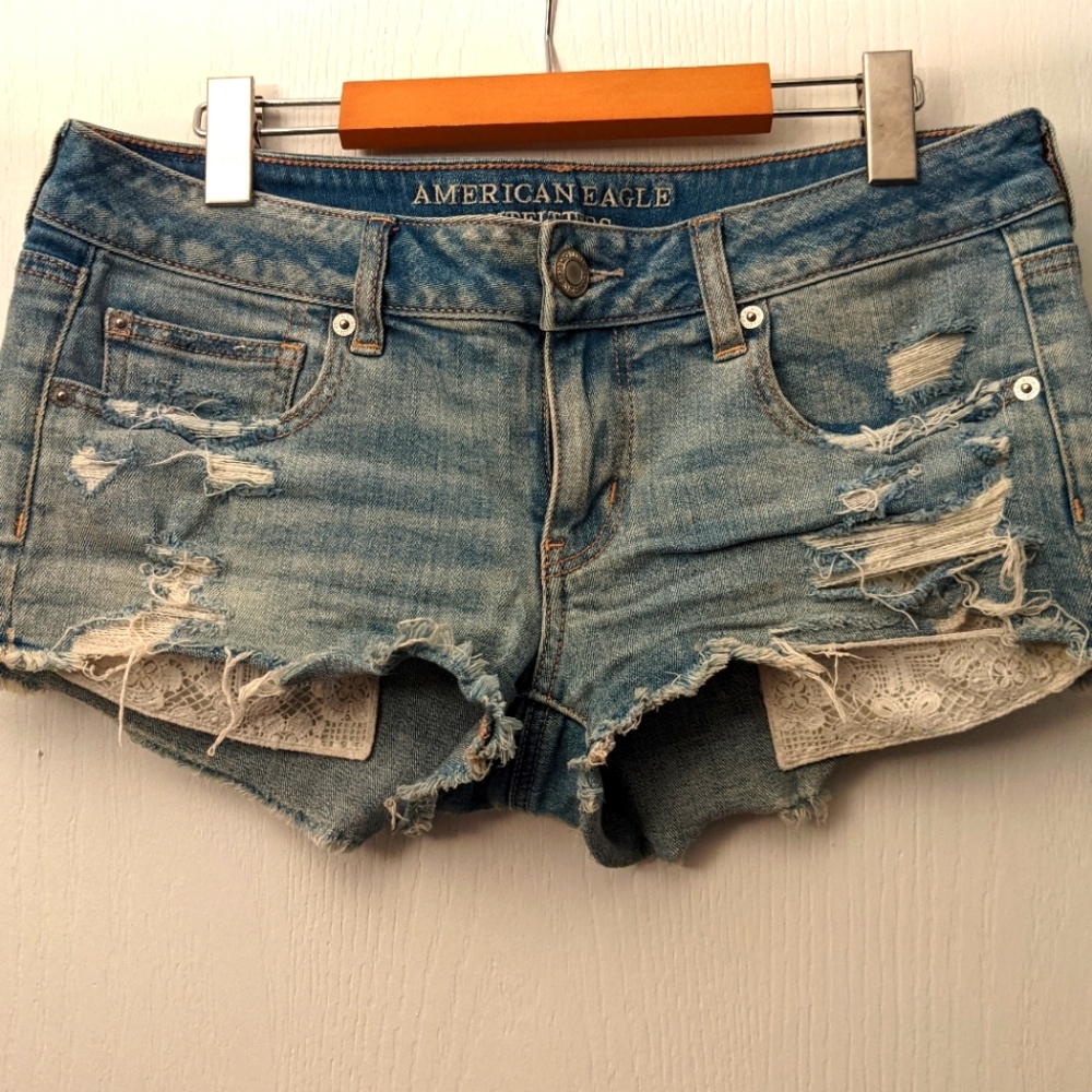 Distressed denim shorts with peekaboo lace pockets